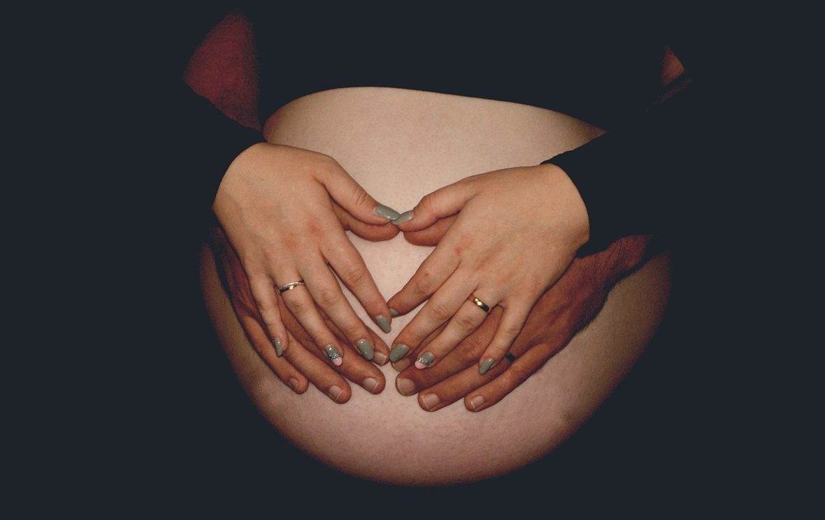 mains sur le ventre d'une femme enceinte