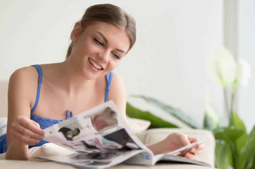femme rigolant en lisant un magazine